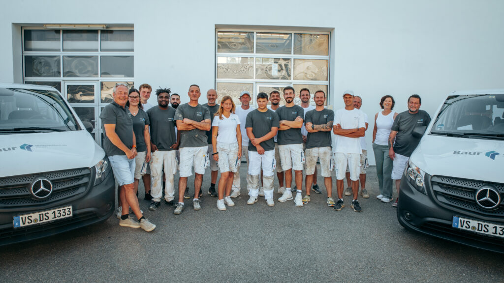 Das gesamte Malerbaur Team vor der Werkstatt.