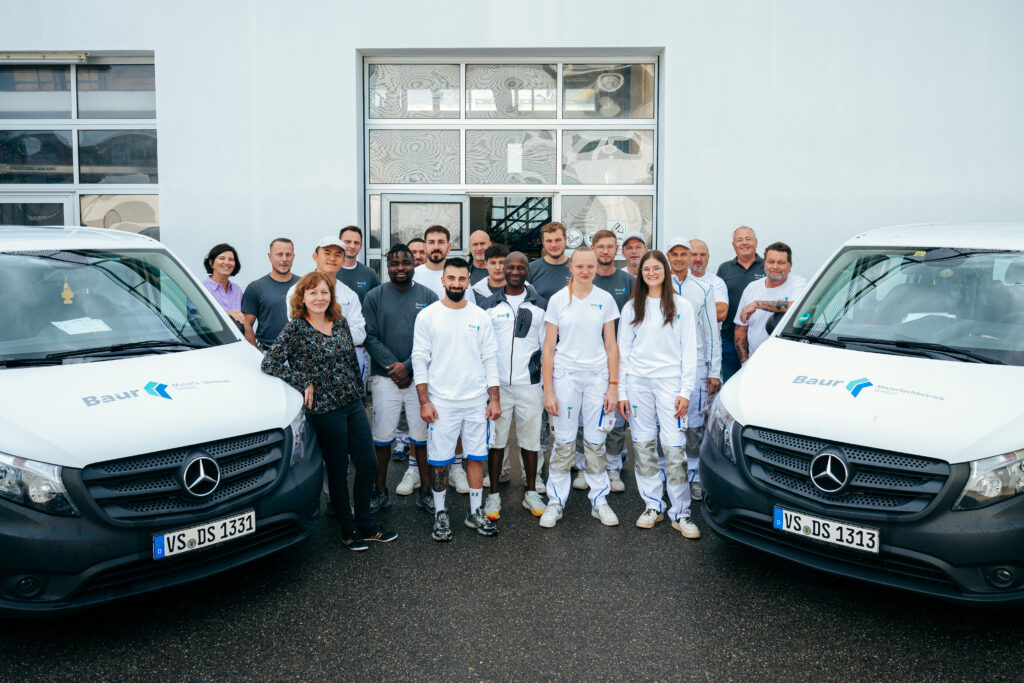Das Malerbaur-Team 2025, vor den Hallen unserer Werkstatt.